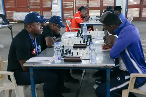 Players in matching caps concentrating during a team chess match